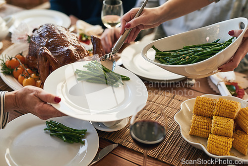 Image of Hands, food and family at a table for thanksgiving, eating and bond on vacation, sharing a meal in their home together. Hand, vegetable and host serving woman during lunch, feast and gathering