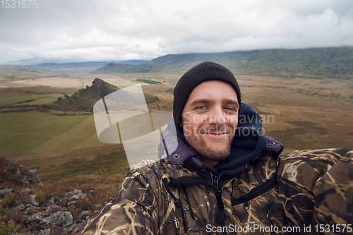 Image of Caucasian man in the mountain making selfie
