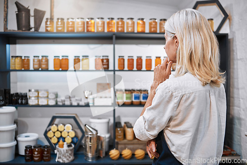 Image of Honey store owner, grocery shop or woman thinking on shelf ideas, sales product price or stock management. Mature, small business or organic supermarket worker planning bee syrup container promotion