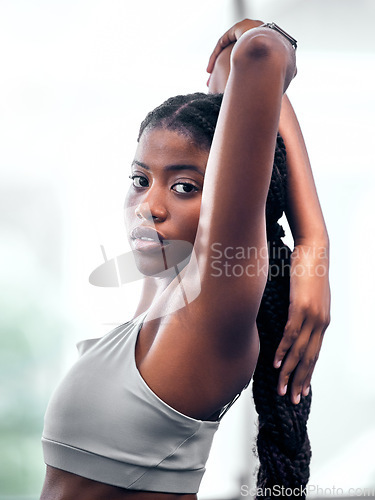 Image of Workout, portrait and black woman stretching arm for self care, wellness and health at club. Exercise, training and athlete warm up in gym for body cardio with serious and determined face.