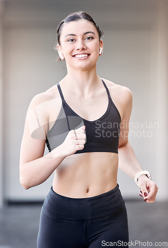 Image of Woman runner, portrait and smile with earphones for music at training, workout or exercise in city. Young athlete girl, happy and running for health, self care or wellness while streaming on internet