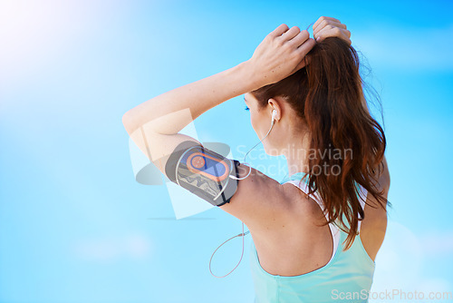 Image of Fitness, woman tying her hair for running workout, health and wellness outdoor. Training, sports runner or healthy girl athlete with mockup blue sky ready for run or start cardio exercise with music