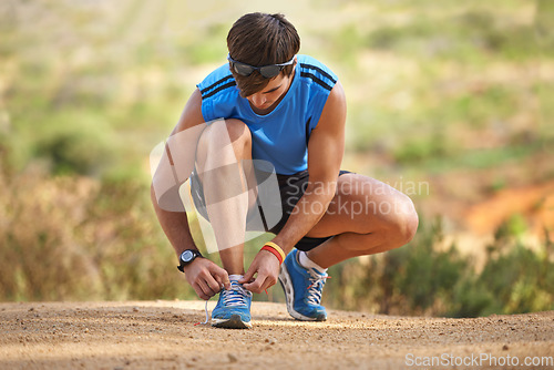 Image of Fitness, shoes and man prepare before running in nature for health, wellness and exercise. Shoes, tying laces and getting ready with athletic man preparing for workout, training and jog or hike