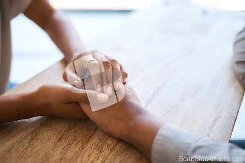 Image of Couple, holding hands and support on table in closeup for help, care and empathy in time of grief. Black couple, helping hand and love to forgive, consult or comfort together in home with kindness