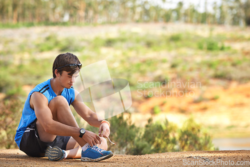 Image of Sports, man and shoes on a floor by runner start fitness, running and cardio exercise in a forest, calm and ready. Health, athlete and sport guy lace tie on ground before marathon training in nature