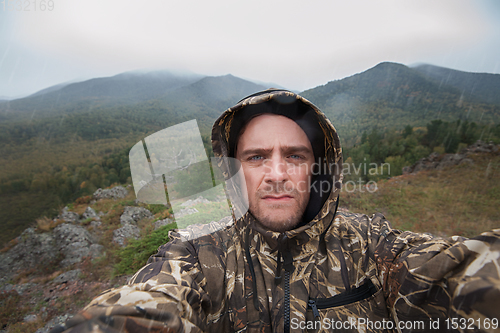 Image of Caucasian man in the mountain making selfie