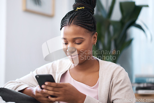 Image of Black woman, social media smartphone and living room sofa relax, typing and online connection, reading notification and iot website. Young african female, mobile app and internet tech on 5g home wifi