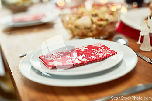 Image of Youre invited. Christmas, celebration and holiday table plate for food, party and dining place setting zoom. Dining room, lunch or dinner to celebrate xmas vacation with festive red snowflake napkin.