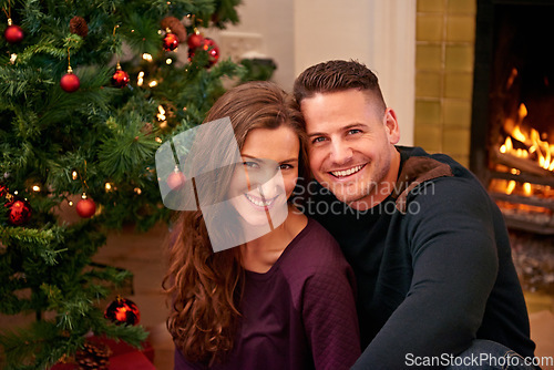 Image of Couple, christmas and portrait together in home with smile, happiness and bonding with christmas tree. Man, woman and happy by fireplace for celebration, party and holiday spirit on living room floor