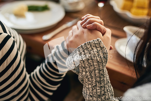 Image of Hands, pray and family at a table for food, blessing and gratitude before sharing a meal in their home together. Hand holding, worship and people praying before eating, prayer and religious respect