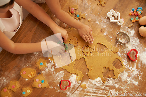 Image of Top view, children hands and baking with cookie cutters in house or family home kitchen with pastry, eggs or sweets. Kids, girls or bonding siblings cooking breakfast biscuits, dessert and wheat food