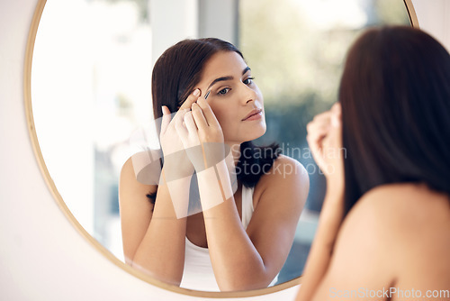 Image of Shape, eyebrow and woman in mirror of bathroom for beauty, microblading and makeup. Luxury, facial and wellness with face of girl at home and tweezers for cosmetics, cosmetology and skincare
