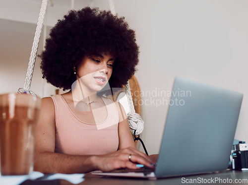 Image of Black woman afro, laptop and designer working, studying or typing email in remote work at home. Stylish African American female freelancer busy on computer in design course or business research