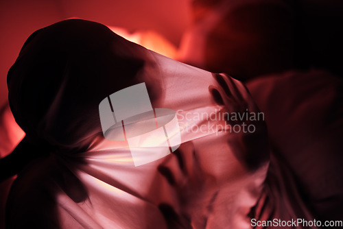 Image of Red lighting, silhouette and hands on sheet for person feeling depressed, trapped and alone. Creative art, psychology and lonely adult with mental health problem, depression and sadness in dark