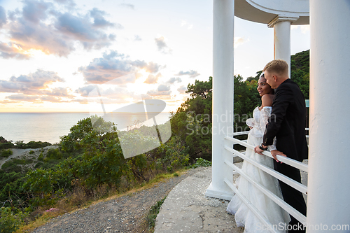 Image of Newlyweds in a gazebo with columns on the seashore