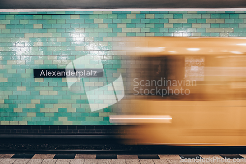 Image of Yellow subway train in motion on Berlin Alexanderplatz underground station.