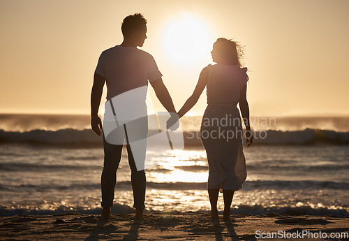 Image of Beach silhouette, couple holiday and sunset with love, hold hands and love together, support and holiday. Man, woman and vacation at ocean, travel and romance for anniversary, honeymoon and sea trip