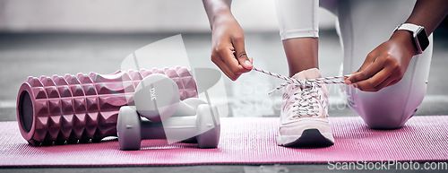 Image of Fitness, weights and woman tying shoes before workout in gym for health, wellness and strength. Sports, training and closeup of athlete with laces to tie while preparing to exercise in a sport center