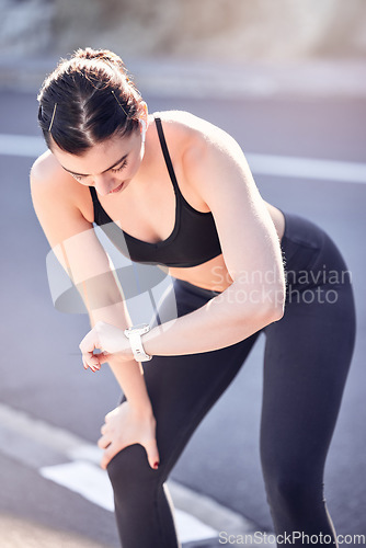 Image of Woman runner, sports watch and running time for outdoor marathon training, cardiovascular exercise and cardio workout on road. Heart rate, race time and smartwatch for tracking vitals or performance