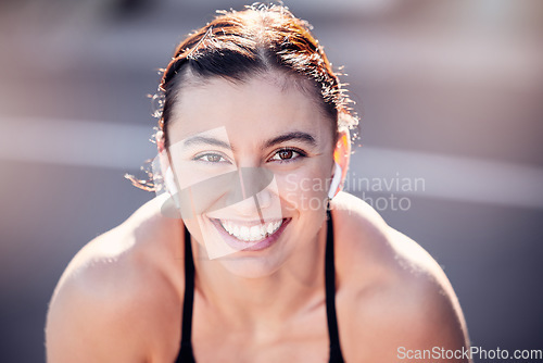 Image of Portrait, face and fitness with a sports woman listening to music while running outdoor for cardio exercise. Happy, smile and workout with a female runner training alone for an endurance marathon
