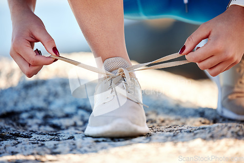 Image of Shoes, running and fitness with a sports woman tying her laces before a cardio or endurance run outdoor. Road, health and exercise with a female runner fastening her shoelaces before a workout