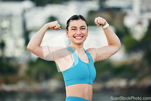 Image of Fitness, portrait and woman flexing muscle, arms or biceps after strength training, workout or exercise for power. Smile, sports and happy strong girl bodybuilder athlete with growth development