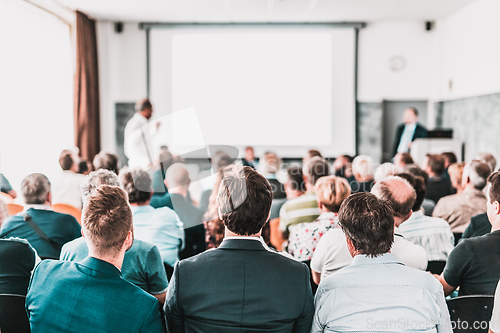 Image of I have a question. Group of business people sitting in conference hall. Businessman raising his arm. Conference and Presentation. Business and Entrepreneurship