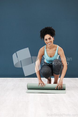 Image of Fitness, yoga and portrait of black woman with yoga mat in studio after fitness class for pilates. Wellness, health and happy girl roll exercise mat after workout, training and stretching in gym