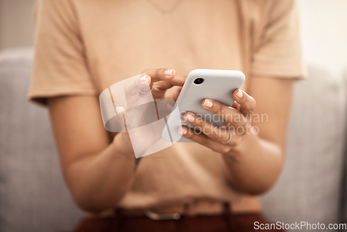 Image of Hands, phone and woman typing on sofa in home living room, texting or scrolling social media. Tech, relax and female on couch in lounge on mobile smartphone networking or internet browsing in house.