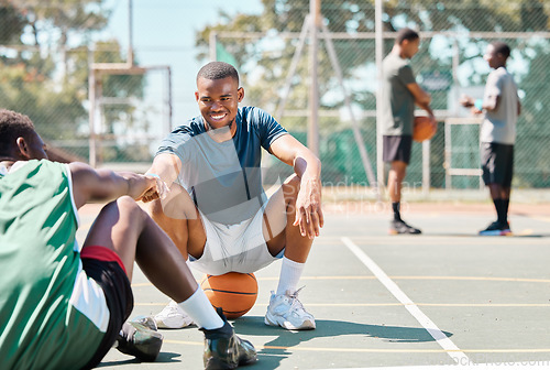 Image of Sports, basketball and friends, men relax and fist bump on basketball court in happy summer. Friendship, teamwork and basketball player sitting on ground with friend and ball in community playground.