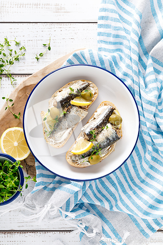 Image of Sardines sandwiches on a white wooden background. Mediterranean food. Top view