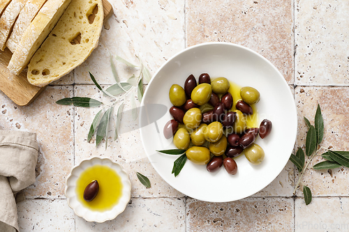 Image of Olives, olive oil and ciabatta, top view