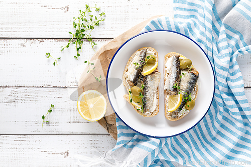 Image of Sardines sandwiches on a white wooden background. Mediterranean food. Top view