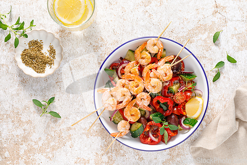 Image of Shrimp kebab roasted on skewers and fresh vegetable salad, top view