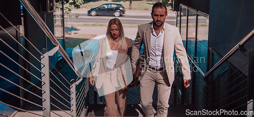 Image of Modern business couple after a long day's work, walking together towards the comfort of their home, embodying the perfect blend of professional success and personal contentment.