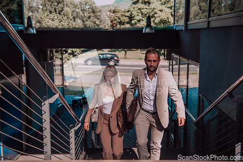 Image of Modern business couple after a long day's work, walking together towards the comfort of their home, embodying the perfect blend of professional success and personal contentment.