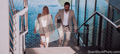 Image of Modern business couple after a long day's work, walking together towards the comfort of their home, embodying the perfect blend of professional success and personal contentment.