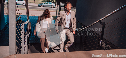 Image of Modern business couple after a long day's work, walking together towards the comfort of their home, embodying the perfect blend of professional success and personal contentment.