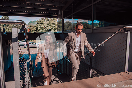 Image of Modern business couple after a long day's work, walking together towards the comfort of their home, embodying the perfect blend of professional success and personal contentment.