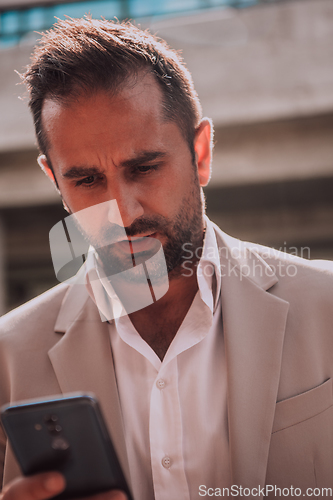 Image of A businessman using his smartphone outdoors, showcasing the seamless integration of technology and mobility in modern professional life.