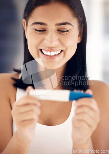 Image of Pregnancy test, happy and smile with a woman reading the results after testing with a home kit in her bathroom. Wow, pregnant and fertility treatment with a female mother to be feeling excited