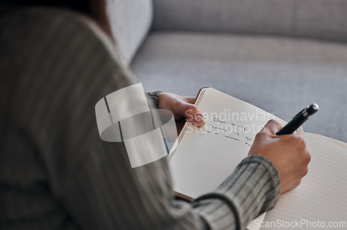 Image of Hand, book and woman writing in journal on a sofa for planning, brainstorm and feeling log closeup in a living room. Notebook, diary and girl with mental health problem write note on emotions in home