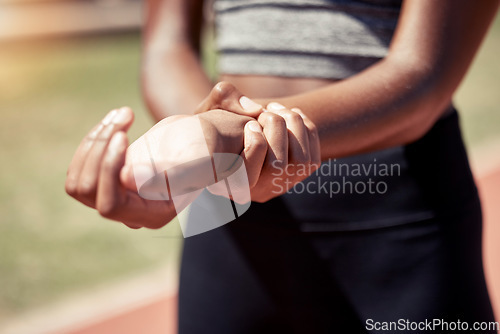 Image of Hands, runner and arm injury from sports exercise, workout or training at the stadium track. Active female suffering in joint inflammation holding painful wrist in discomfort, strain or sore bruise