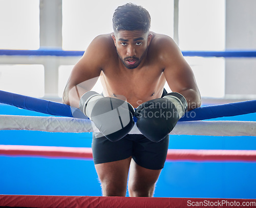 Image of Boxing ring, man and tired from fight, training and workout in gym exercise, burnout and fail in competition games. Portrait sweating boxer, athlete and guy, break and breathing in sports arena club