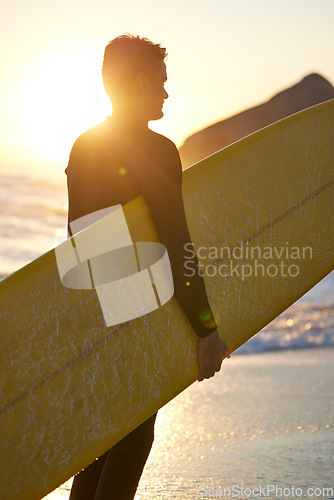 Image of Beach, surfer and man with a surfboard at sunset thinking of of fitness training, workout or water sport exercise outdoors. Silhouette, freedom and healthy athlete on a holiday vacation for surfing