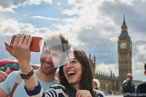 Image of Travel, phone and couple take a selfie in London to post outdoor city street content on social media. Big ben, freedom and happy woman loves taking pictures with partner on a fun holiday adventure
