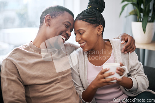 Image of Love, coffee and couple relax on a sofa, talking and embrace in the morning in their home. Black couple, man and woman enjoy tea on couch, bond and share sweet conversation in a living room together