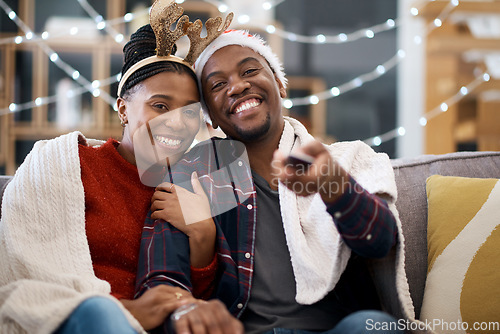 Image of Watching tv, couple and relax on a sofa for christmas show, movie or film in living room in a home. Love, tv and man with woman portrait on couch for festive celebration tv show, channel and surfing