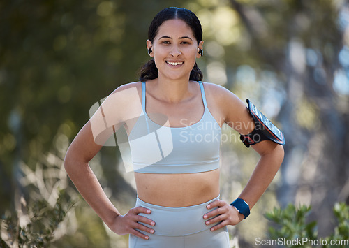 Image of Portrait, runner and happy woman, arm band and earphones of music, motivation or fitness in nature, sports and cardio. Young athlete, healthy lifestyle and park training, exercise energy and wellness