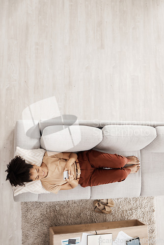 Image of Above view, black woman and sofa of a person on phone wifi looking at web and social media app. Living room lounge couch of a woman using mobile technology to relax at home in the morning on internet